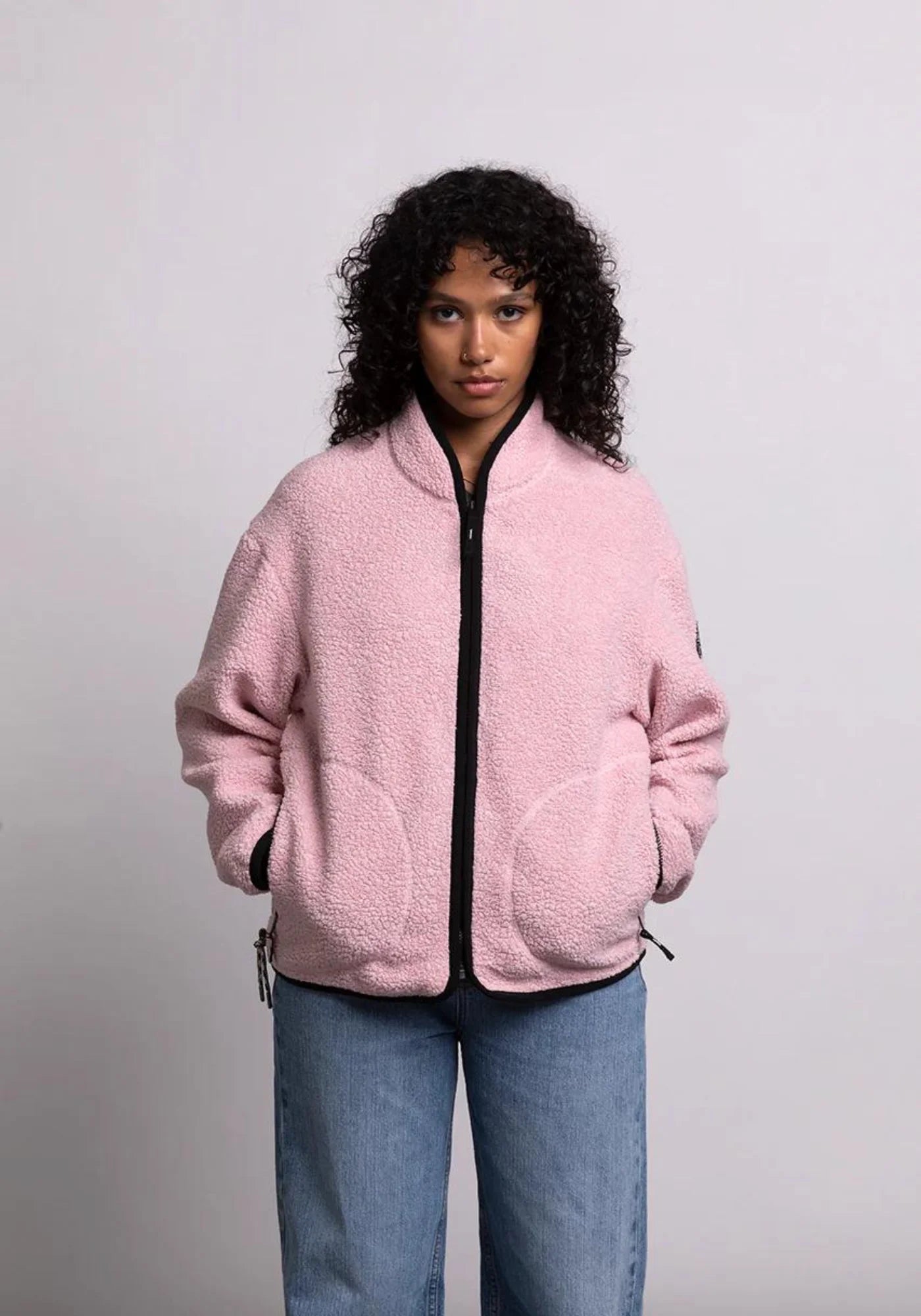 zoom sur la femme qui porte la veste sherpa unisexe kanga rose de chez mout mout 