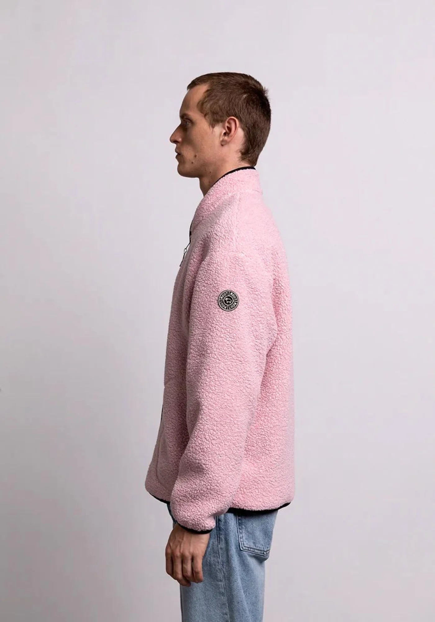 L'homme est de coté et porte la veste sherpa unisexe kanga rose de chez mout mout 