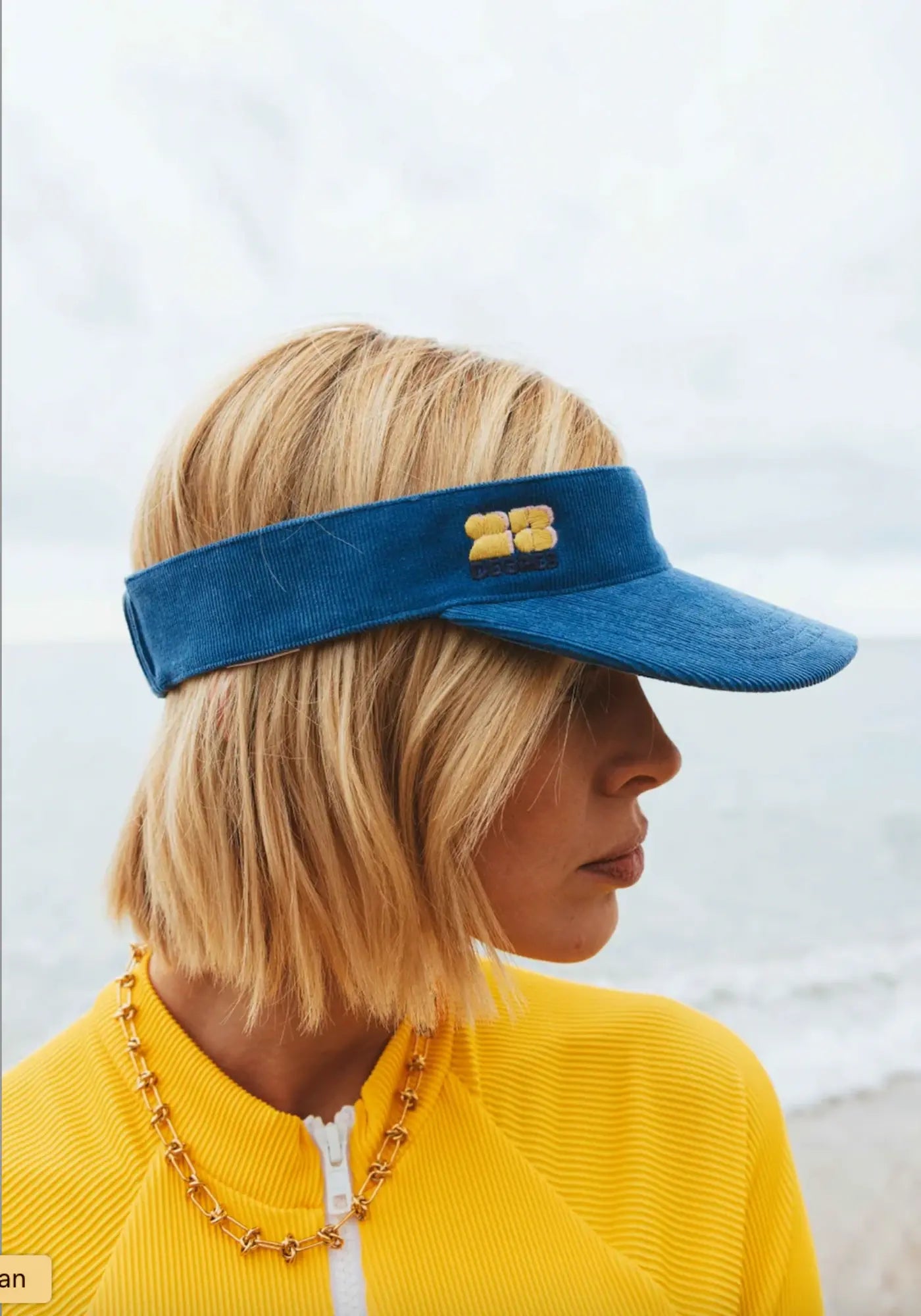 La femme porte la visière sunset bleu de chez 23 Degrés