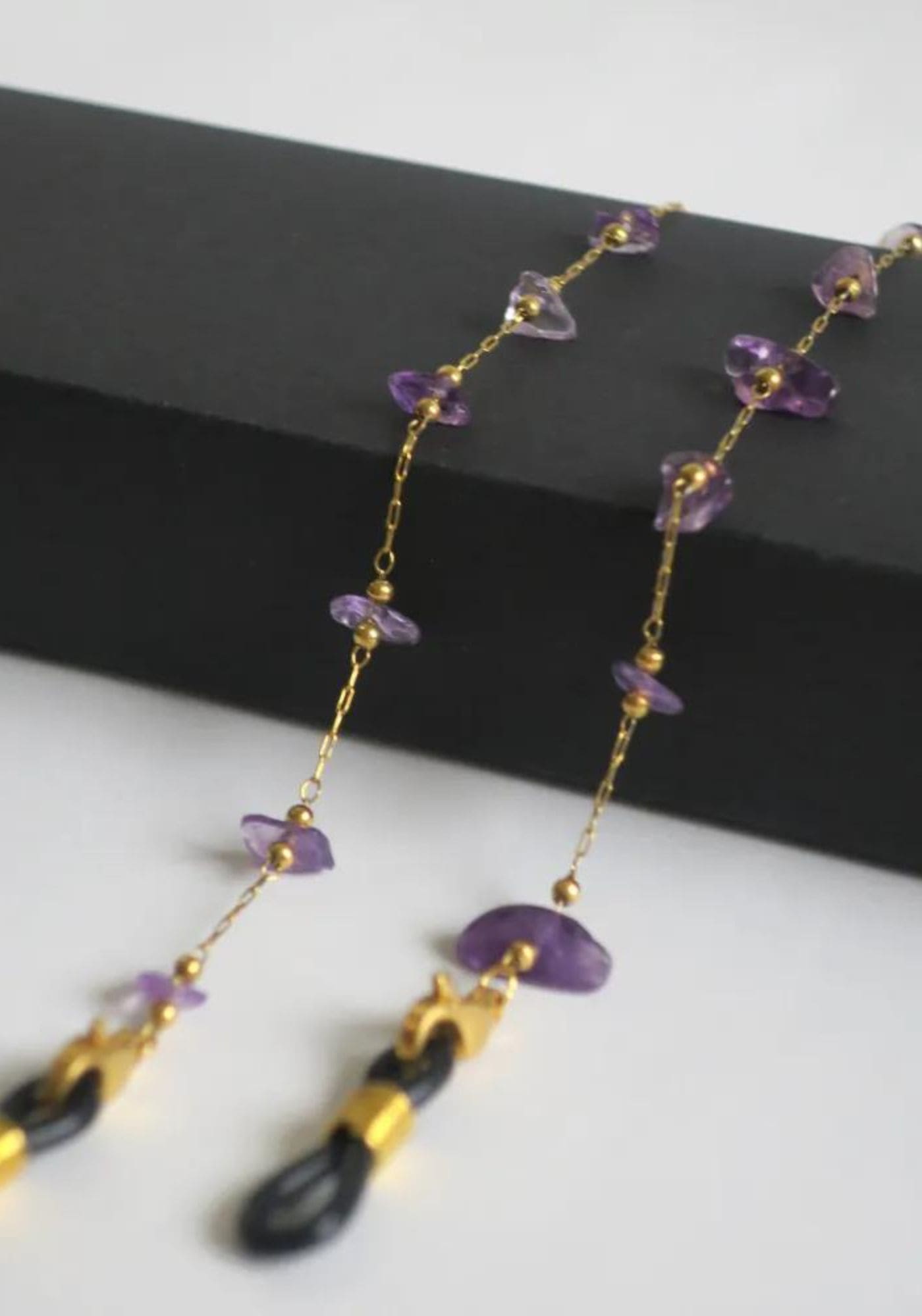 Zoom sur la chaîne de lunettes Aurore avec des pierres violettes de chez Atelier Kat H